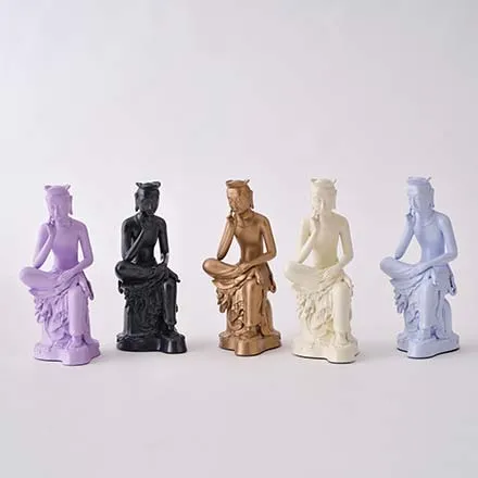 Five miniature figures of a seated, thoughtful bodhisattva in different colours: lilac, black, bronze, cream and pale blue.
